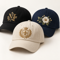 Custom embroidered hats with monogram, crest and floral designs